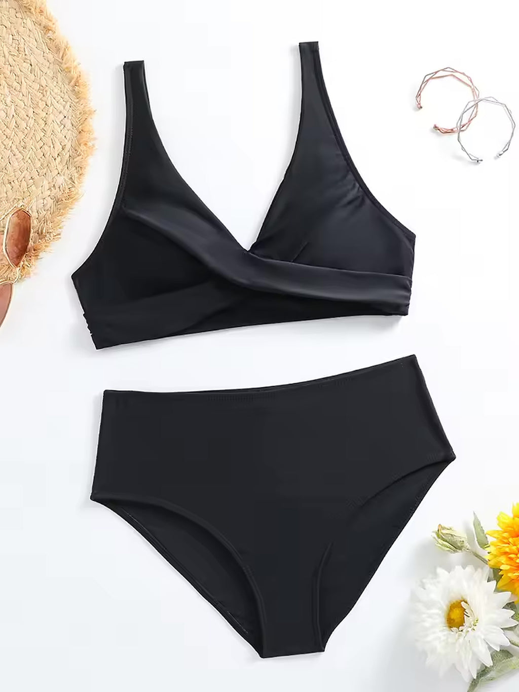 Black Olivia bikini two-piece swimsuit with surplice top and high-waisted bottom displayed flat lay with beach accessories