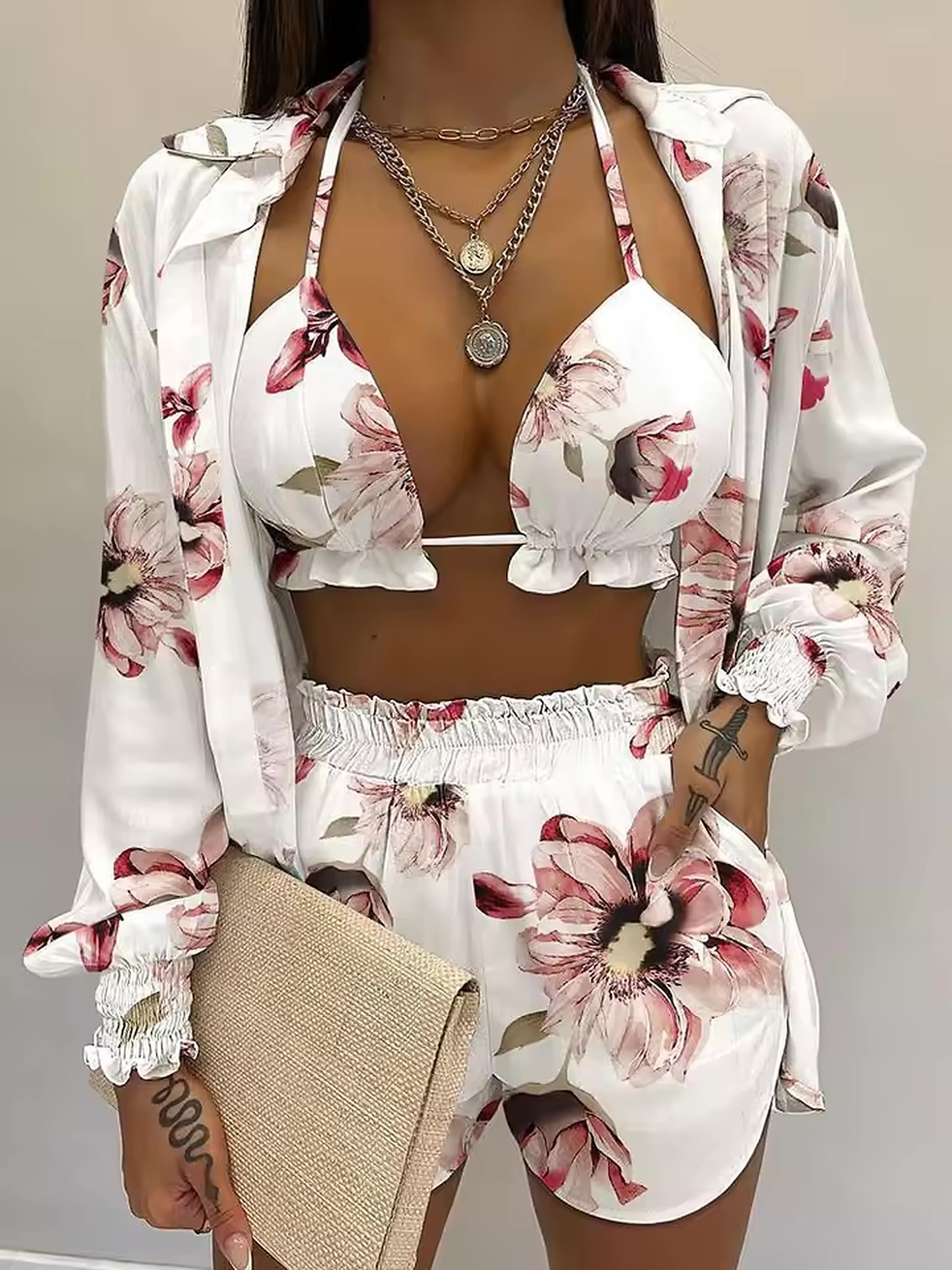 White bikini top with pink floral print, paired with matching swim shorts and coordinating shirt.