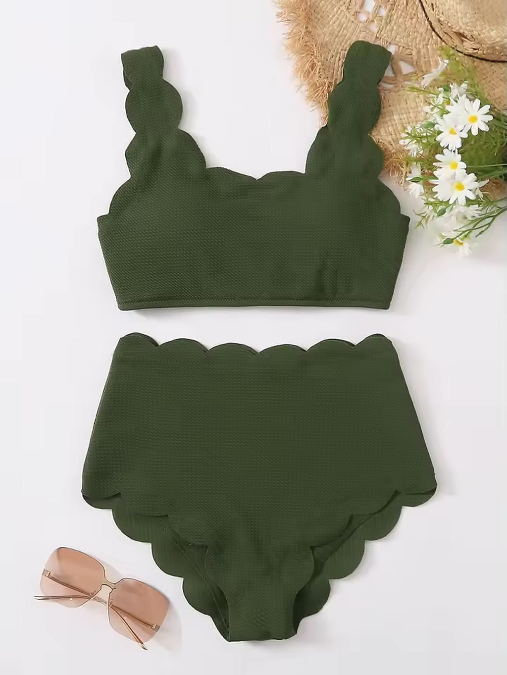 Green scalloped bikini with textured fabric, displayed flat with sunglasses and daisies