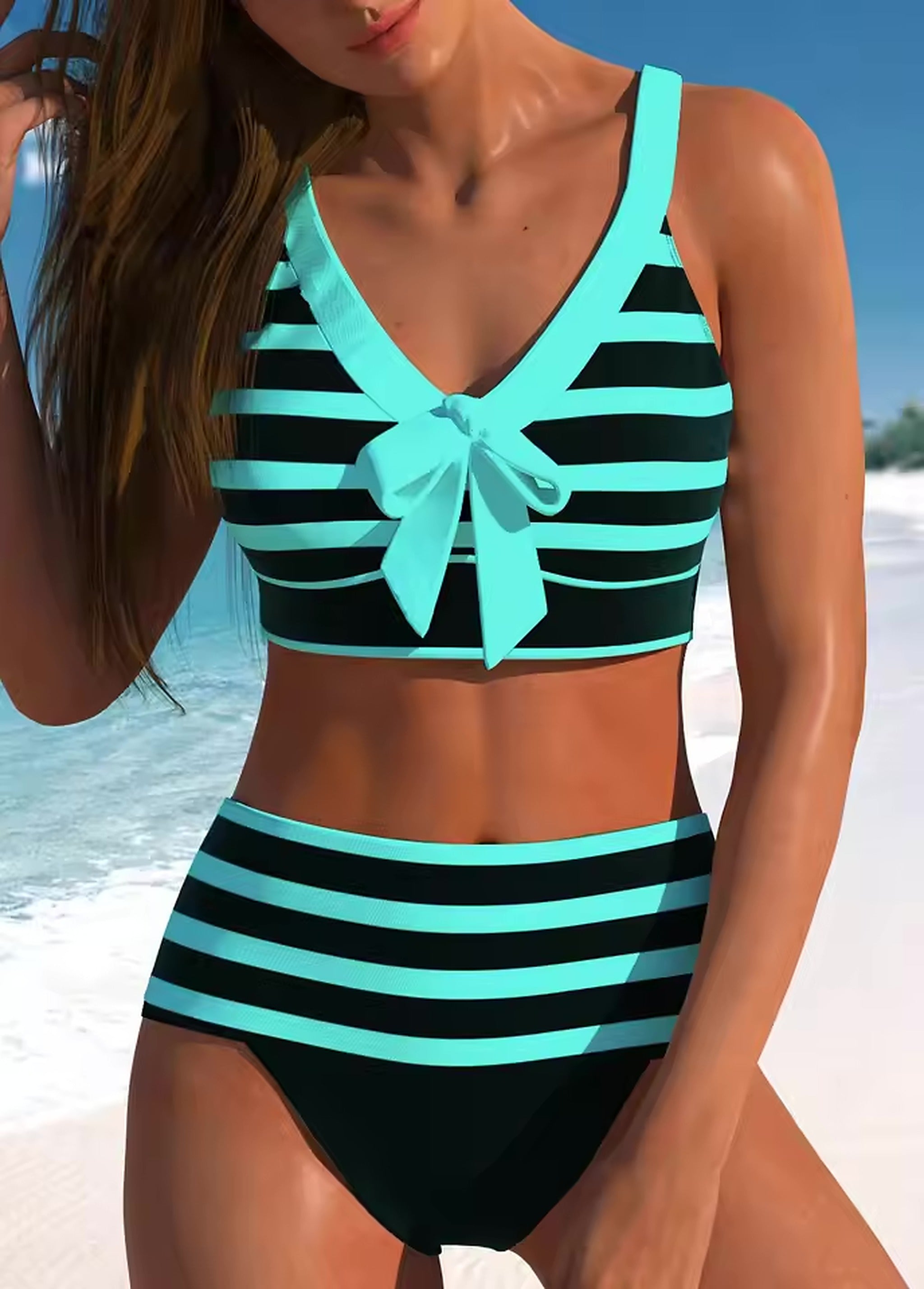 Woman wearing turquoise and black striped bikini with bow detail on beach against blue sky.