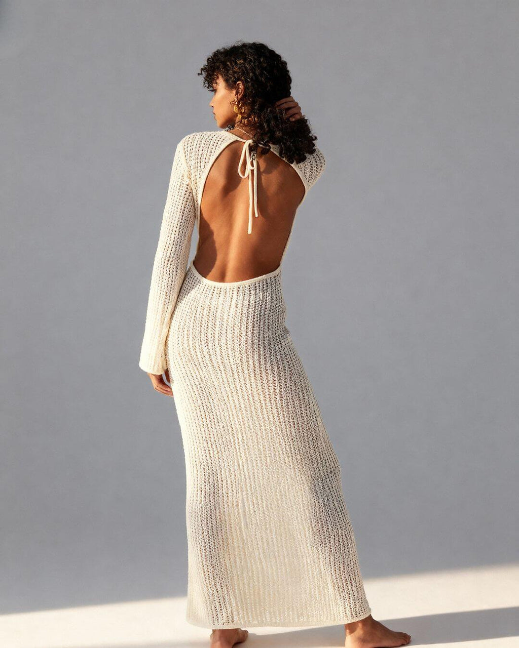 Cream knit bikini with long sleeves and open back tie closure, shown from behind on model