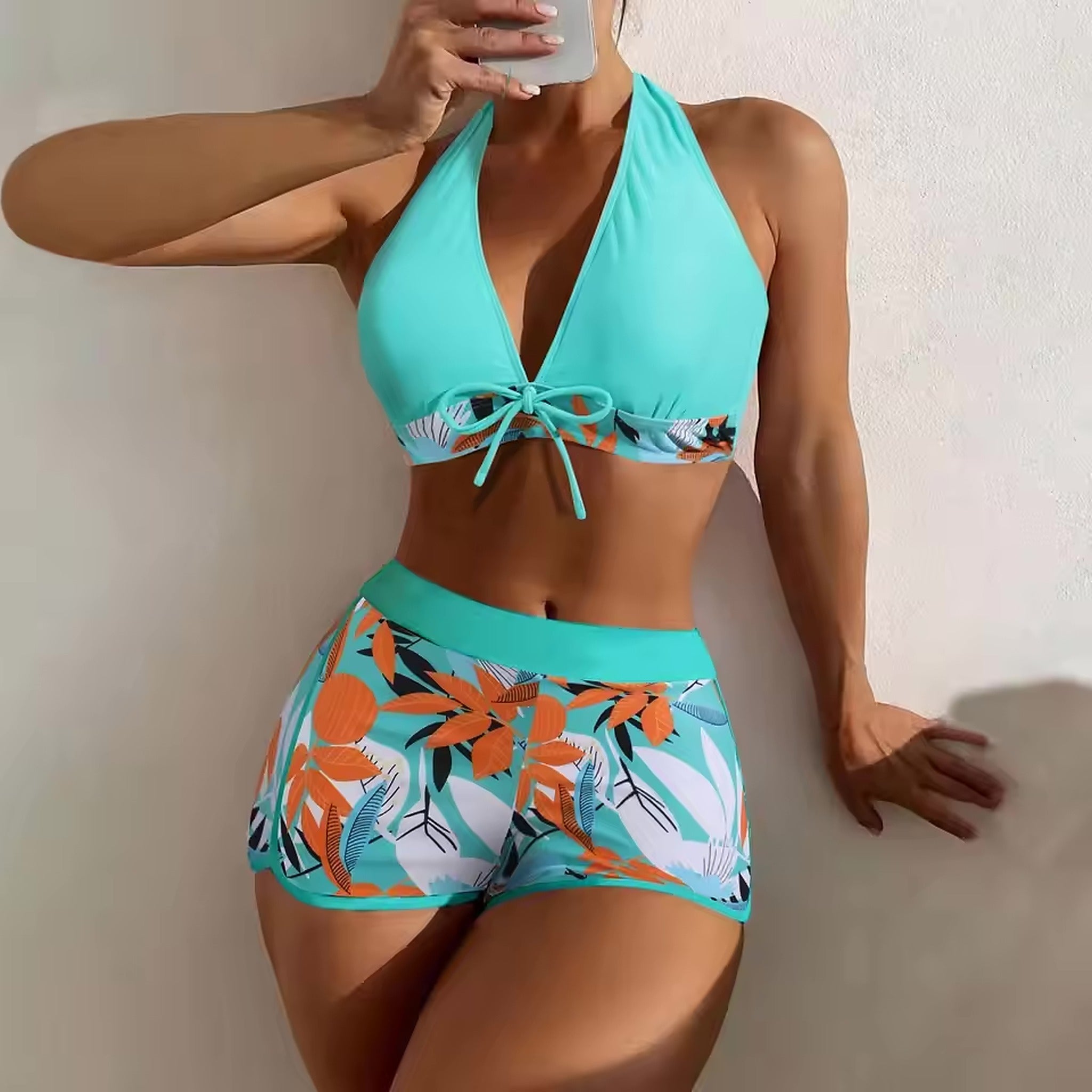 Turquoise halter bikini with tropical floral print shorts and matching solid top with tie detail