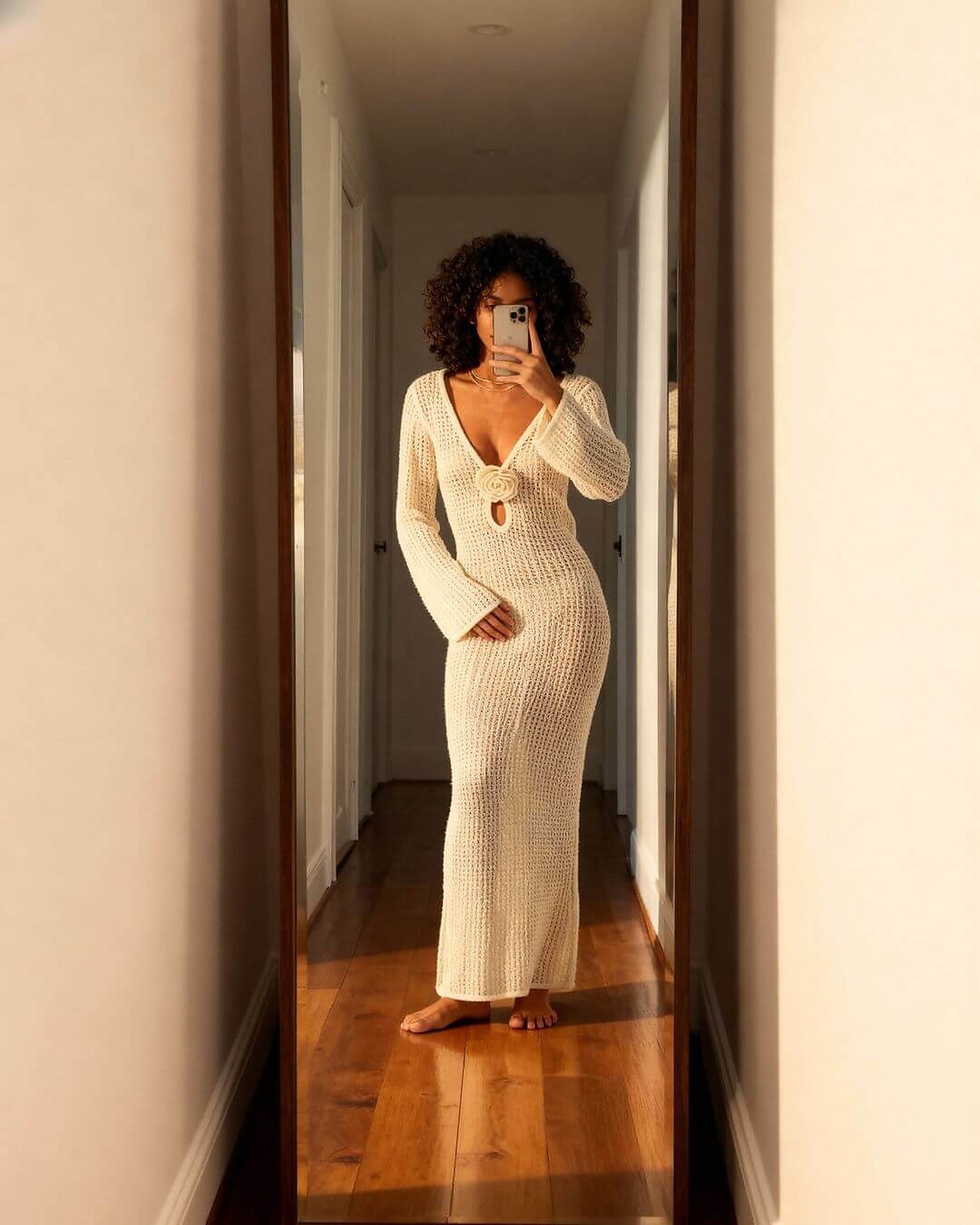 Woman wearing cream knit bikini with long sleeves and cutout detail in mirror selfie