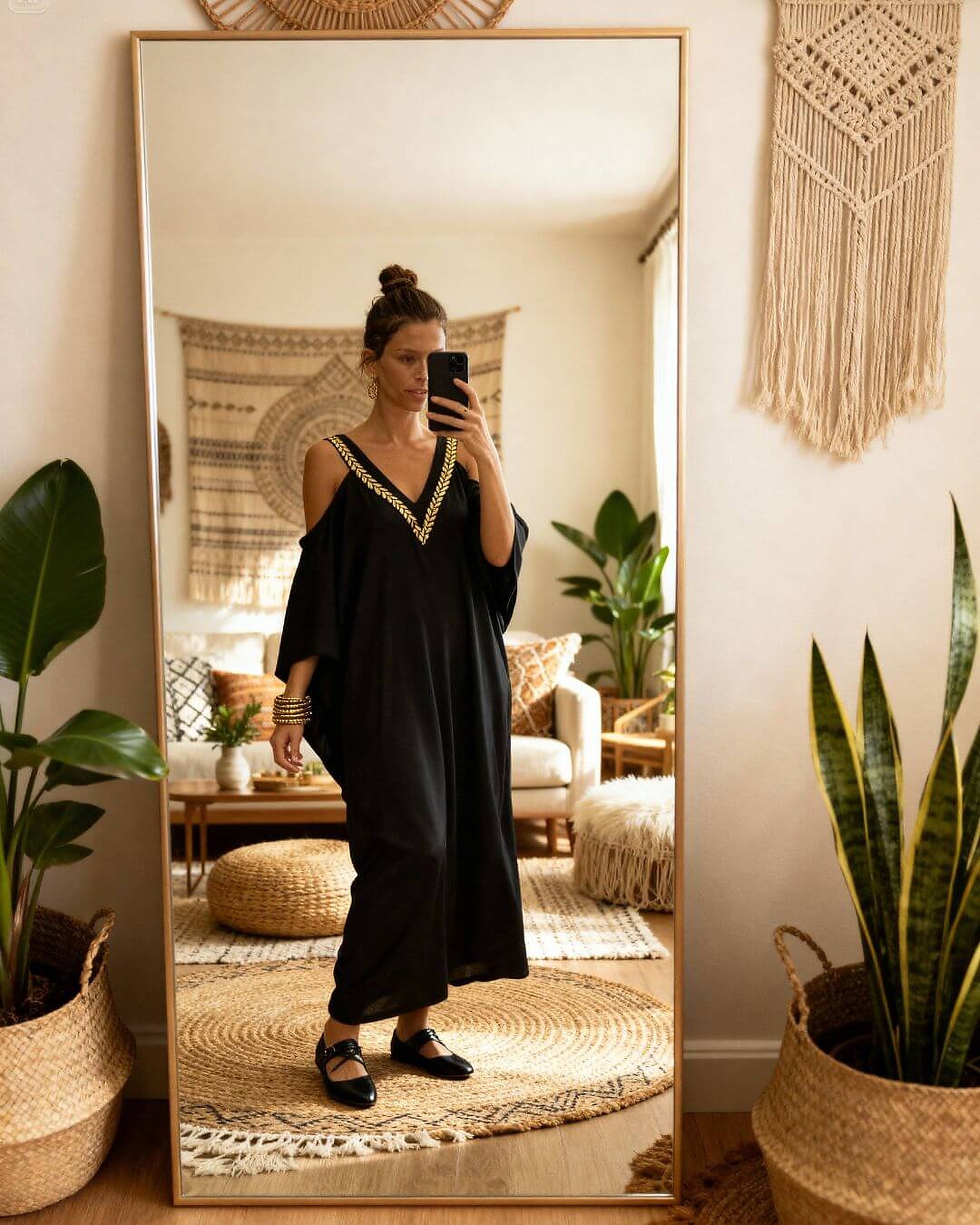 Black cold-shoulder bikini with gold trim detail, styled as cover-up dress in minimalist Scandinavian interior