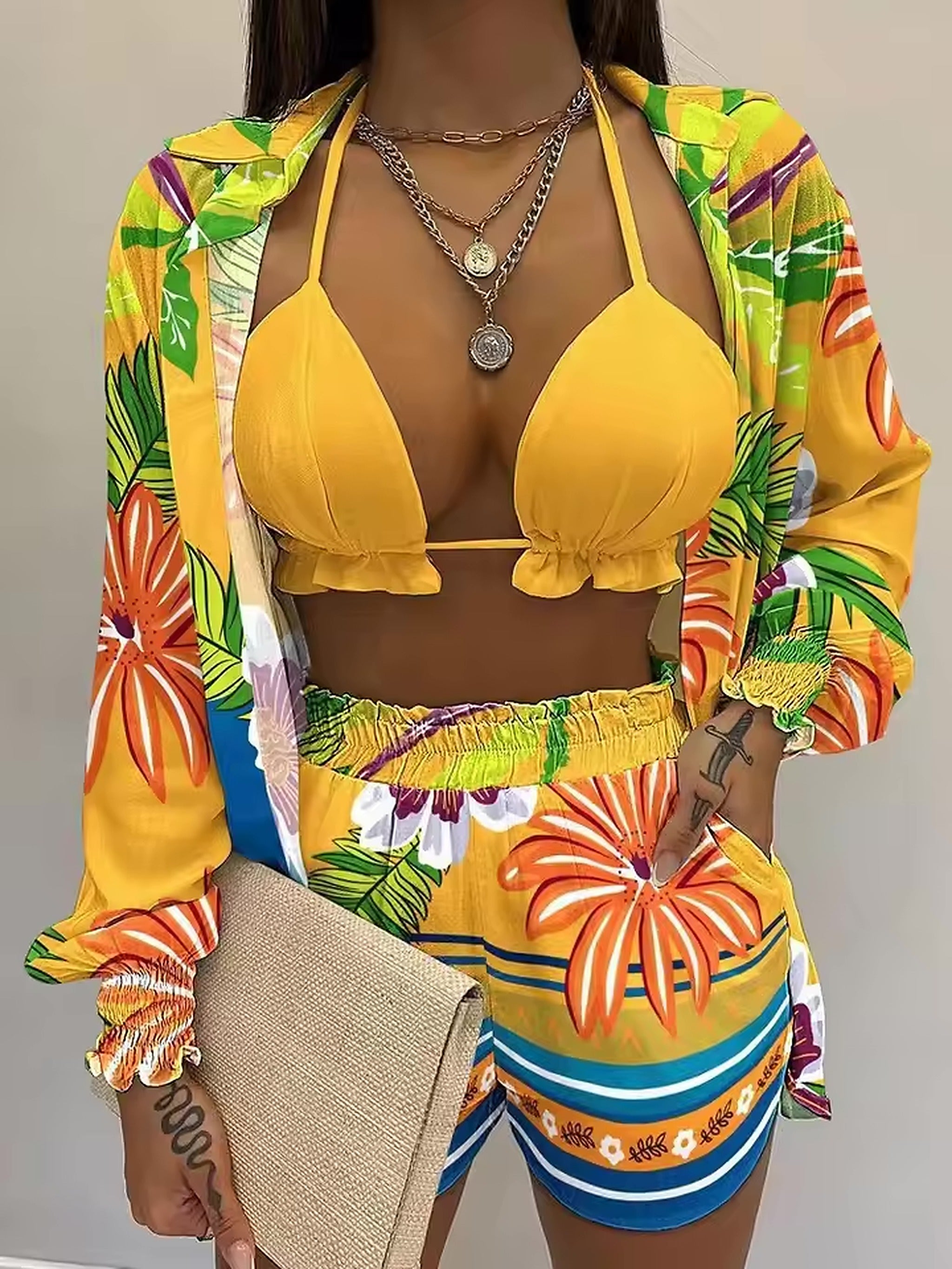Yellow bikini top with vibrant floral print cover-up and matching swim shorts with colorful striped details