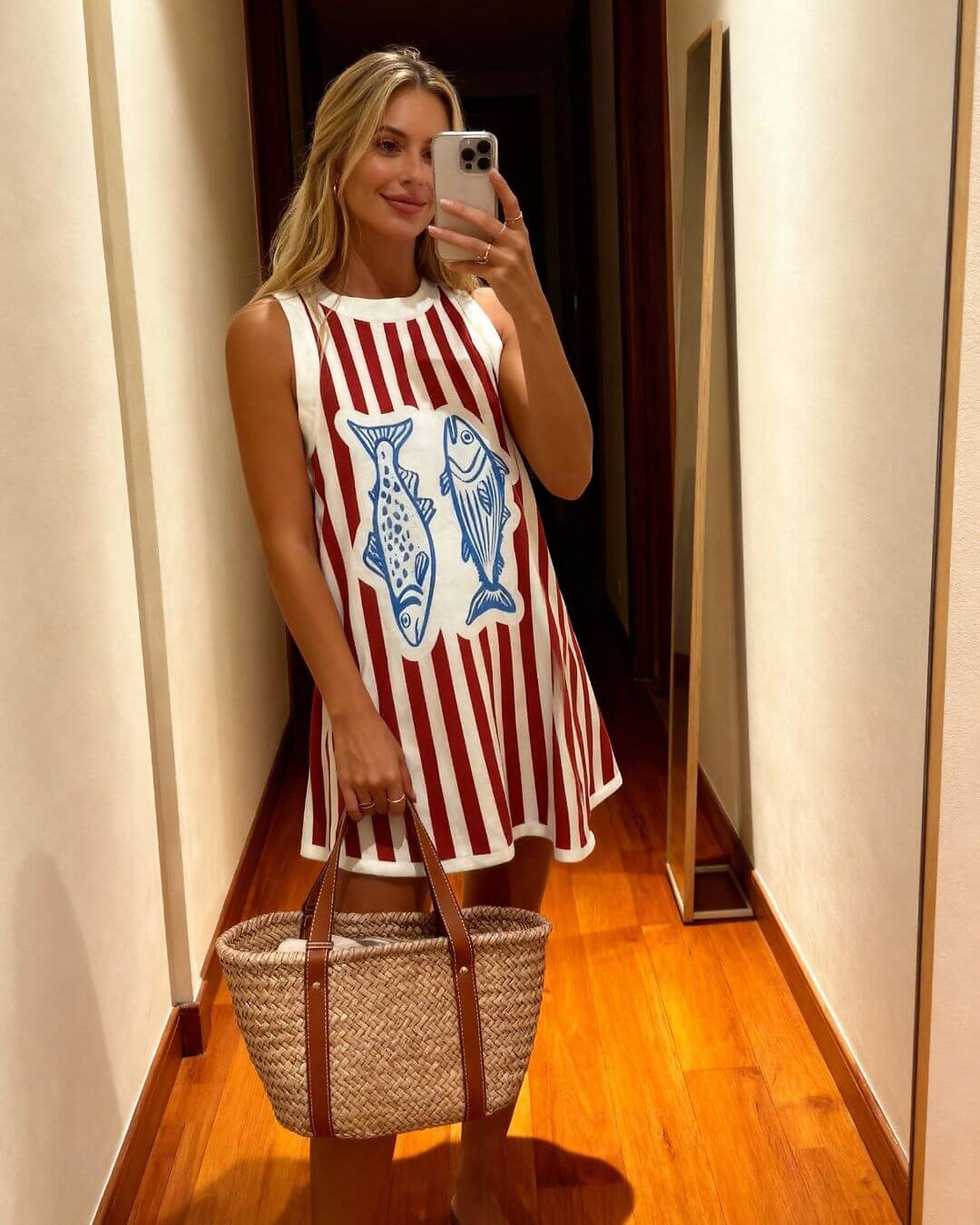 Woman wearing red and white striped bikini dress with blue fish graphic print design