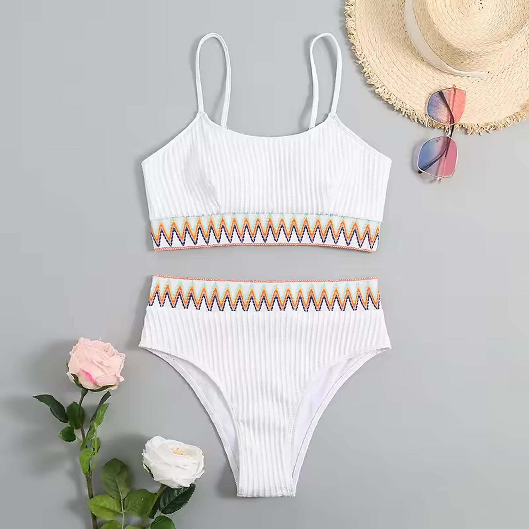 White ribbed bikini with colorful geometric trim, styled with straw hat and sunglasses