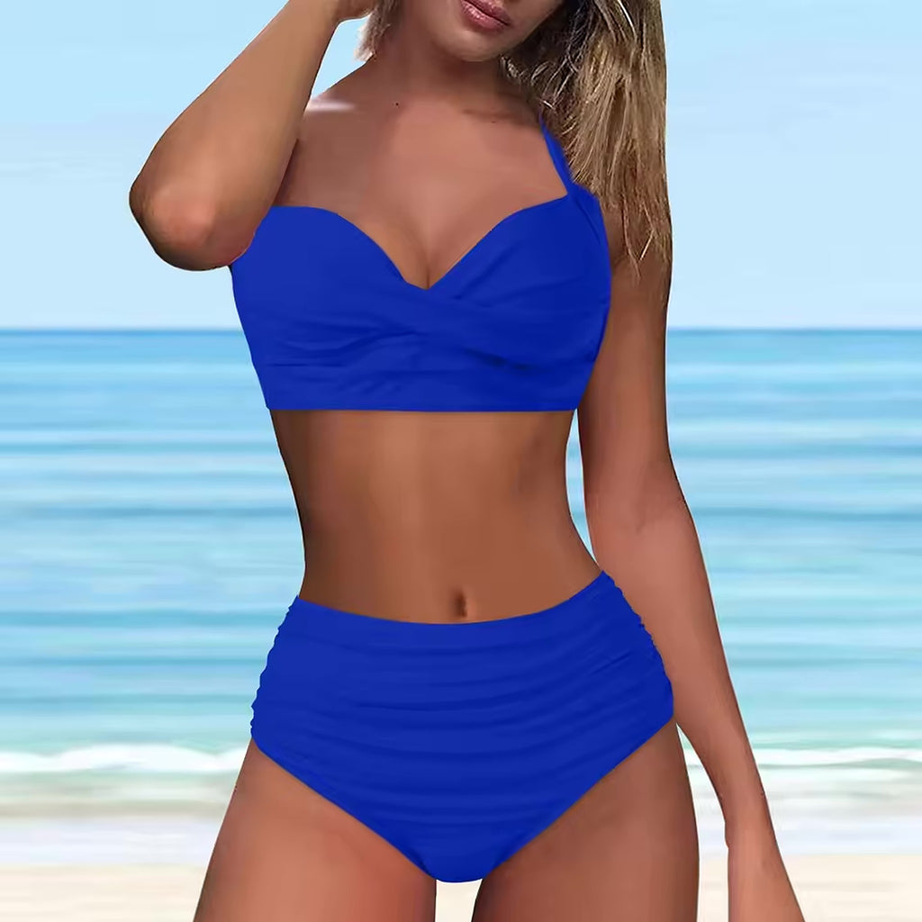 Woman wearing bright blue sweetheart bikini with ruched high-waist bottoms on beach with ocean background