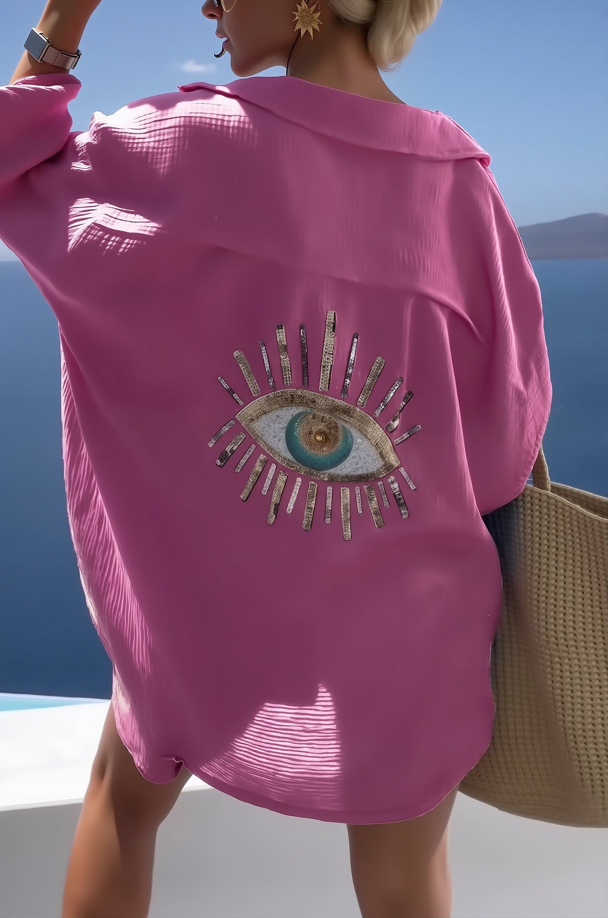 Woman wearing magenta Costa Coral bikini with embellished eye design, overlooking Mediterranean seascape
