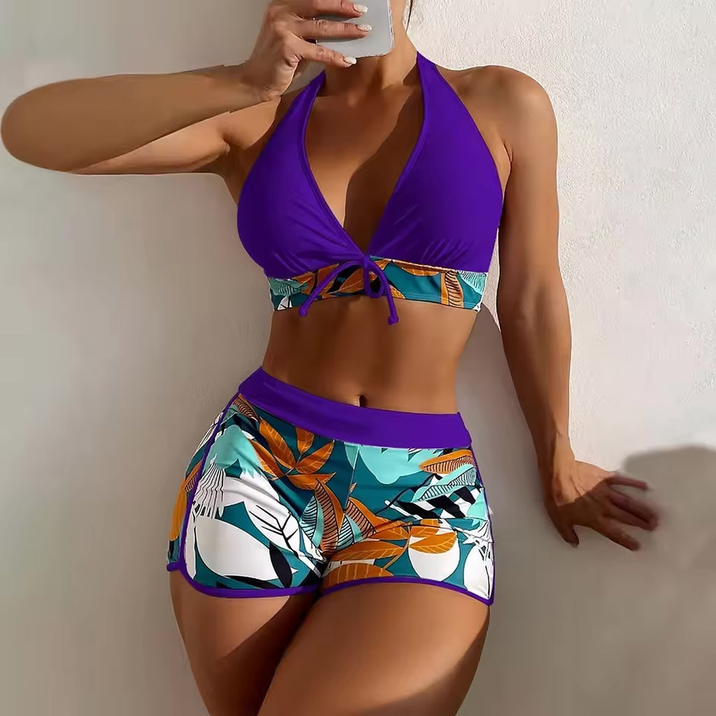 Purple halter bikini top with tropical print band and matching shorts with geometric leaf design